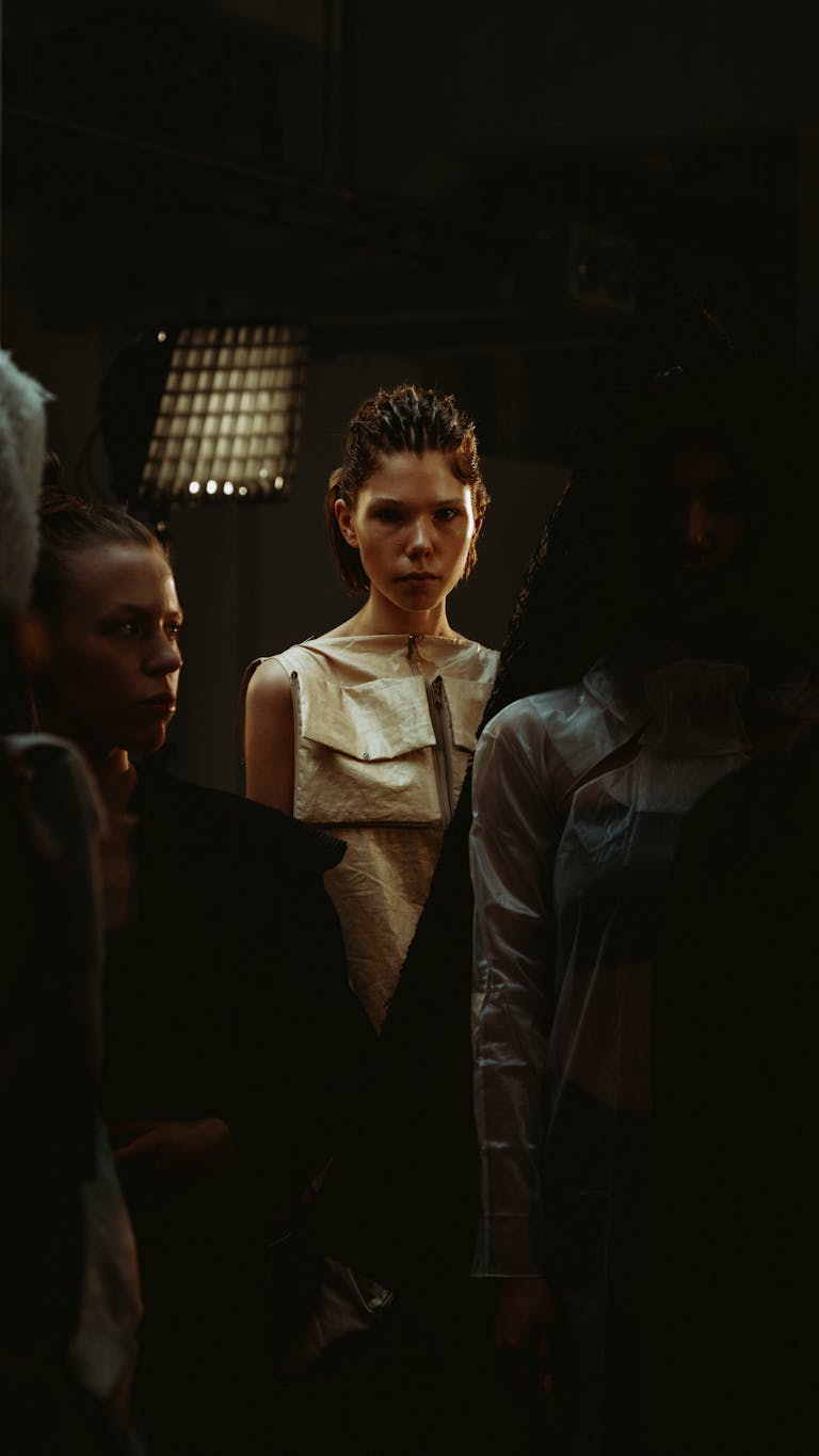 Backstage scene at a Berlin fashion show featuring models in dramatic lighting.
