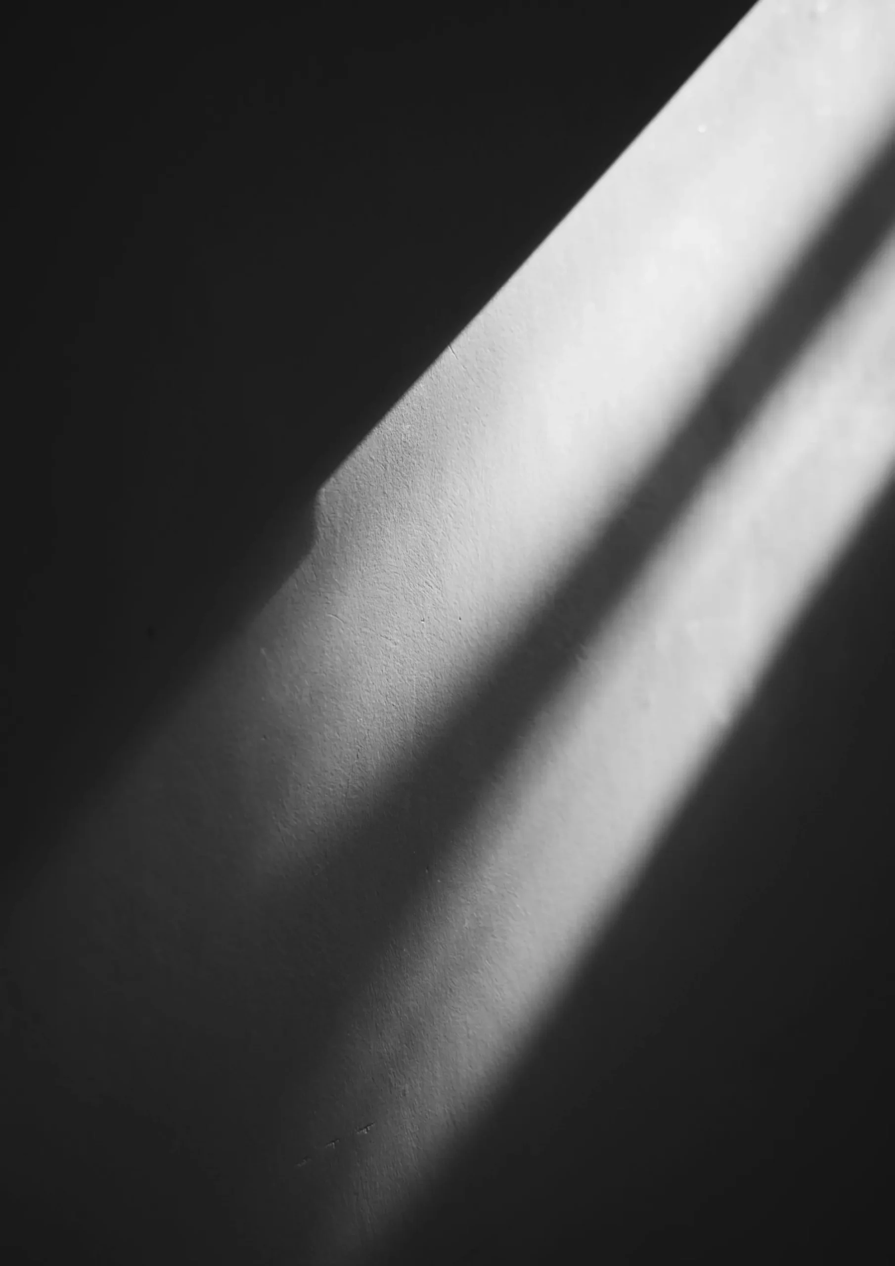 Abstraktes Bild einer Wand, die beleuchtet wird. Schwarzweiß.